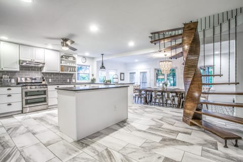 Open kitchen and dining area are complemented by a beautiful staircase.