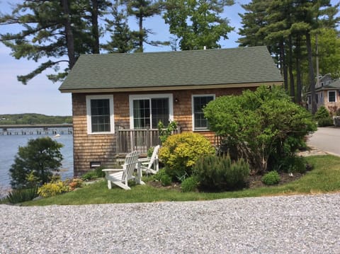 Exterior of cottage and side yard with Adirondack chairs