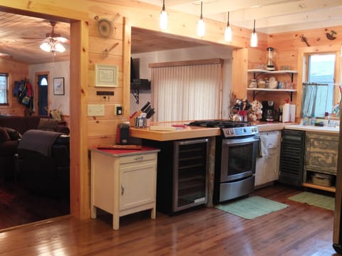 Kitchen, stainless steel gas stove, wine fridge, bar & entry to Great Room