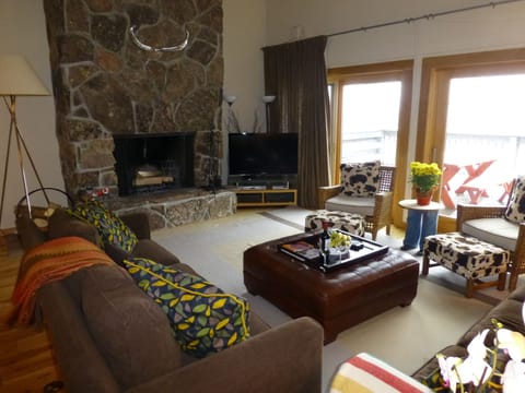 Living room with wood burning fireplace and flat screen TV