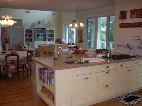 Chefs kitchen with prep sink, gas stove, pasta faucet and serving counter.