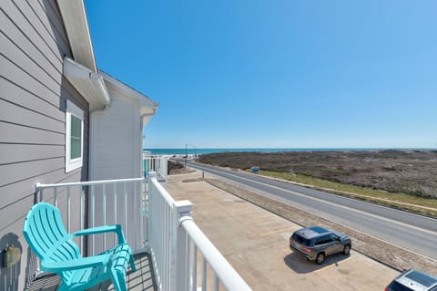 Stunning ocean views from your private balcony, where turquoise chairs invite morning coffee moments overlooking endless blue skies and coastal beauty.