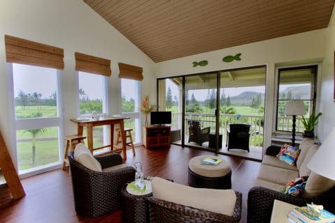 Living room, dining table and wrap-around view of mountains and golf course