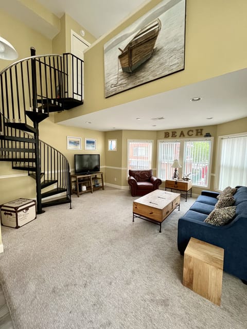 A bright, airy main living area shows the spiral staircase to the loft bedroom.