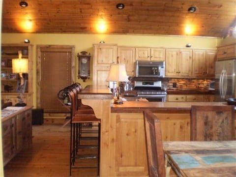 HIGH END CHEF'S KITCHEN WITH FOUR BAR STOOLS AND RECLAIMED WOOD DINING TABLE