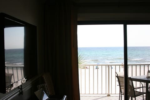 From living room looking past flushmount TV on left at ocean view over balcony.
