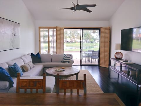 Bright & airy living space. Shutters open to back patio, with golf & lake view.