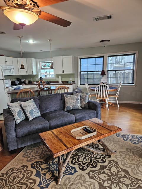 Welcome inside to an open living room, kitchen, and dining area.