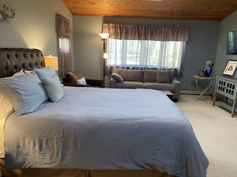 Queen size bed, full sofa, and chairs in sitting area.