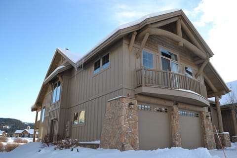 View of grand house in winter; large balcony, view of creek, mtns and meadow on other side