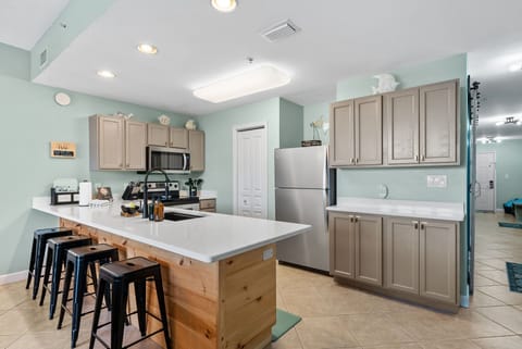 Fully stocked kitchen with stainless steel appliances and counter seating