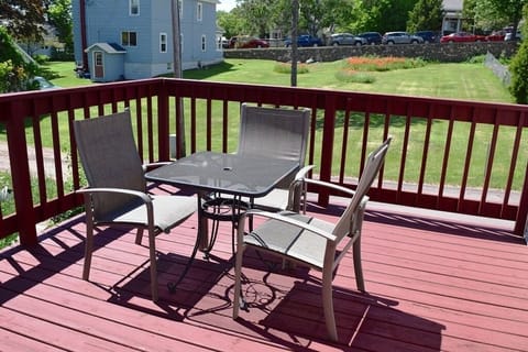 Large deck with table and chairs. Looks out at lawns, alley. homes, (No Lake Vie
