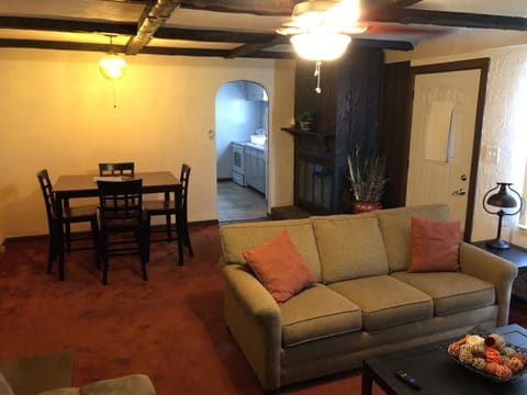 Living Room with pullout couch, futon, 55” Smart TV, and dining room table. 