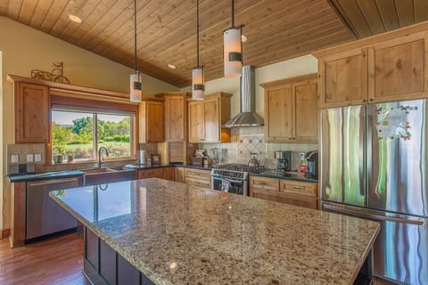 granite counter tops knotty hickory cabinets Hubberton Forge lighting