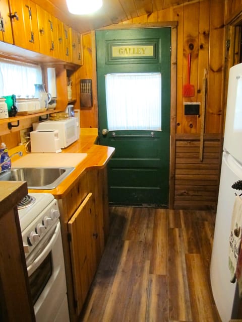 Kitchen with four burner stove and oven  Refrigerator with freezer 