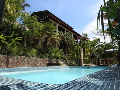Pool, gardens and house on top of hill