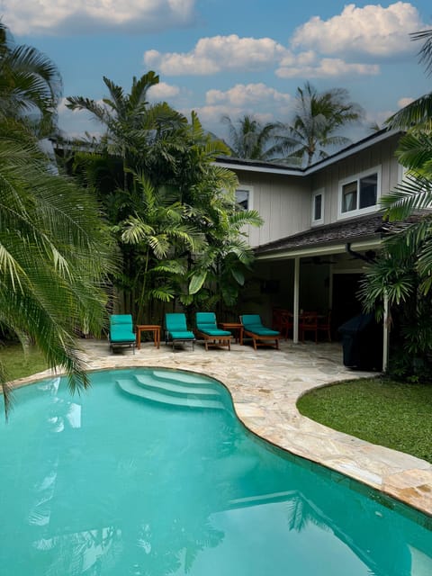 Lushly landscaped private back yard with pool and covered lanai