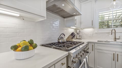 Kitchen features a 6 burner Wolf gas range and oven.