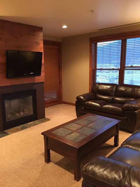 Living room with gas fireplace and large flat-screen TV. 