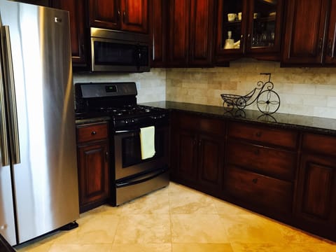 Kitchen w granite counters top, stainless steal application and travertine floor