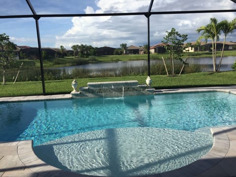 Heated private pool with pretty water feature under cage.