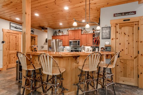 4 unique, handmade dining seats with swivel feature placed around bar top. 2022.