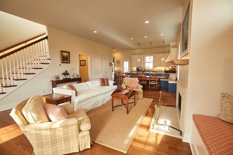 Living room space with cozy reading nooks, TV and working fireplace.