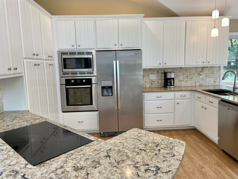 Quartz counters, vaulted ceilings, and Bosch appliances in this upscale kitchen