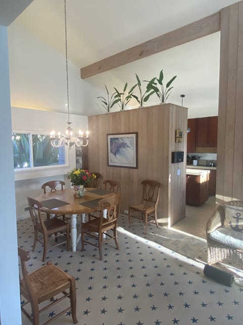 Dining area close to the kitchen, has a high ceiling, and views of palm trees