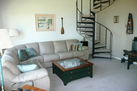 Living room with spiral staircase to loft