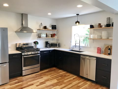 Kitchen fully stocked with pots, pans, dishes, utensils