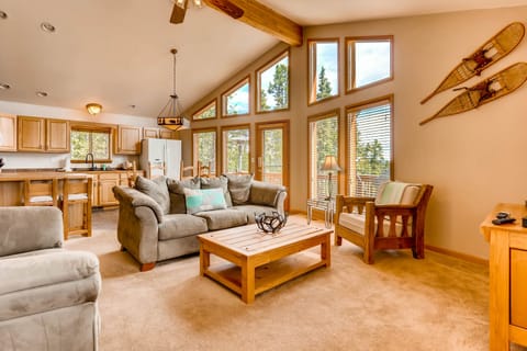 The large living room has vaulted ceilings and floor-to-ceiling windows.