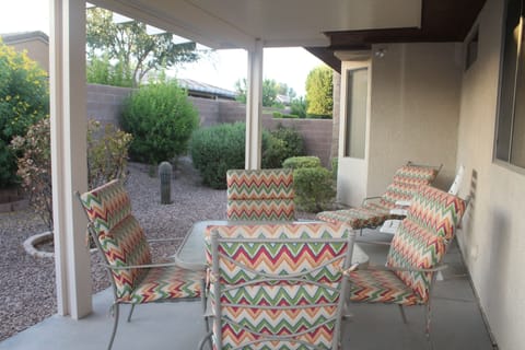 Patio table and chairs, chaise lounge accent the back patio with privacy wall