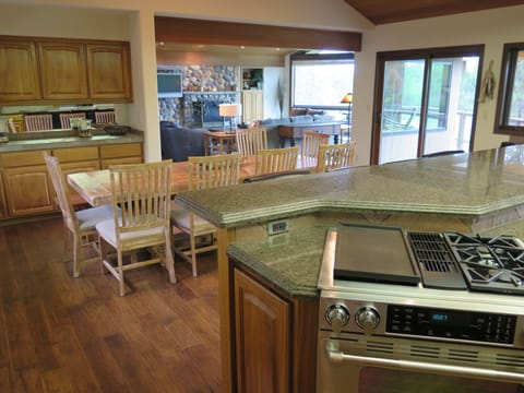 View from kitchen into great room, river-rock stone fireplace.