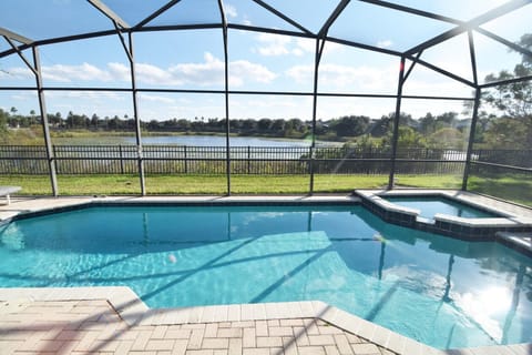 Beautiful south-facing pool deck with lake views, loungers, dining area