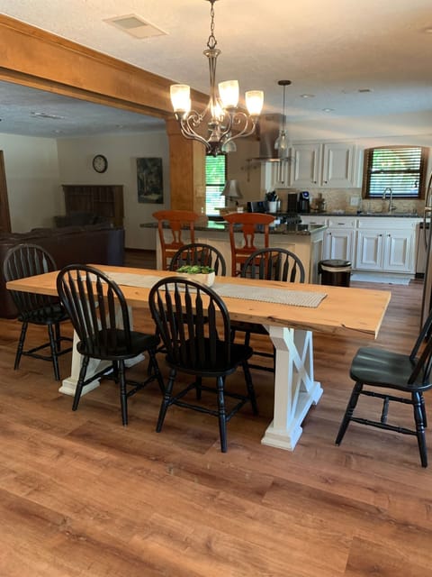 Closeup of dining area with kitchen in the background. Owners can provide more chairs if needed.