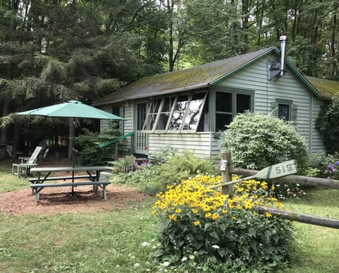 Summer cabin with daisies. 
Parking by split rail fence.