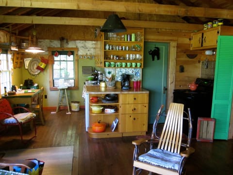 View of front room. 
Kitchen area with sink, stove, table