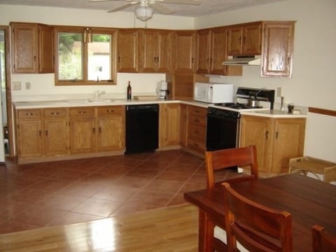 spacious kitchen is stocked for serious cooking! great flower garden view.