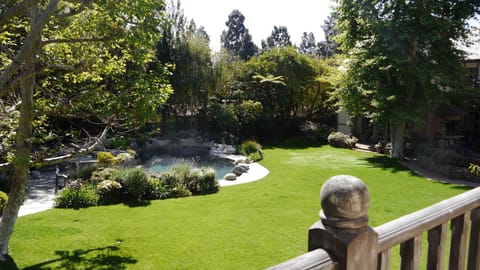 View from the sun porch of the pool, pond and manicured grounds.