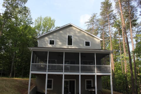 Back of house and screened top level porch facing the water