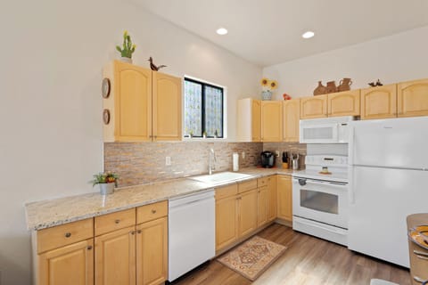 Clean and stocked with cooking pots, pans, dishes, glassware and utensils