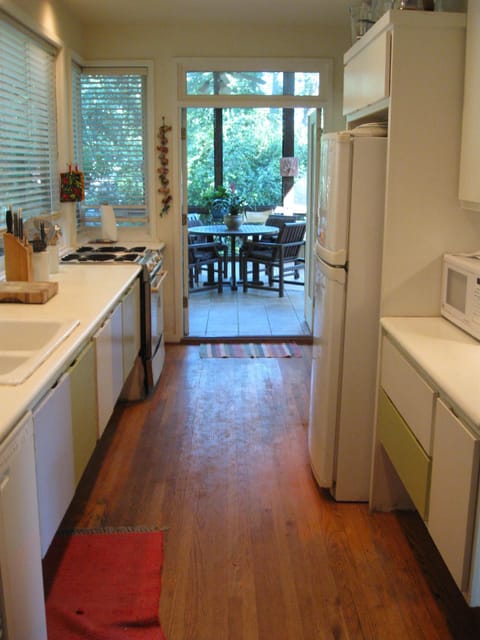 Kitchen opening out for dining on screen porch