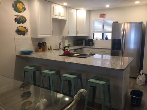 New open kitchen has SS appliances, breakfast bar and is well stocked. 