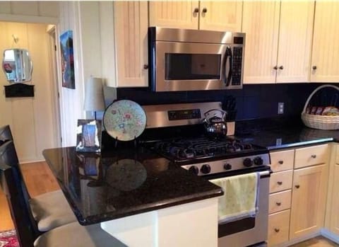 Stainless steel, gas range, and granite make this perfect for gourmet meals.