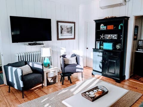 Charming living room with flat screen TV and plenty of comfortable seating.