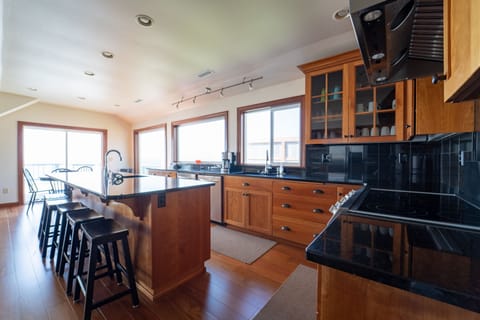 Enjoy the kitchen  oriented to see the ocean and family having lunch on the deck