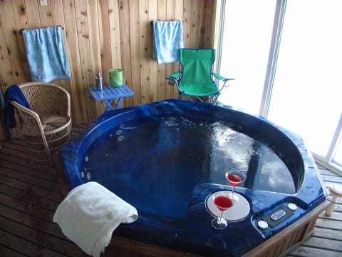 Hot tub comfortably seats 6, in solarium with frosted windows for privacy.