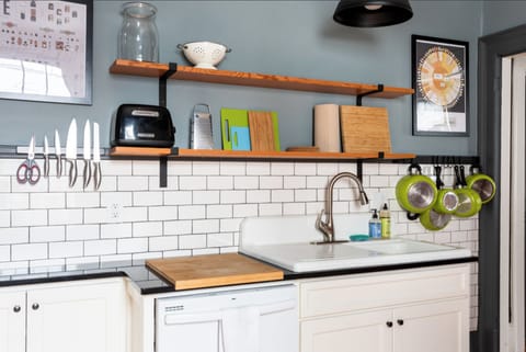 Second kitchen, w/vintage sink, open shelving, and cooking utensils