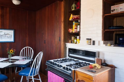 Kitchen, stove view with shelves for food and dishes.
